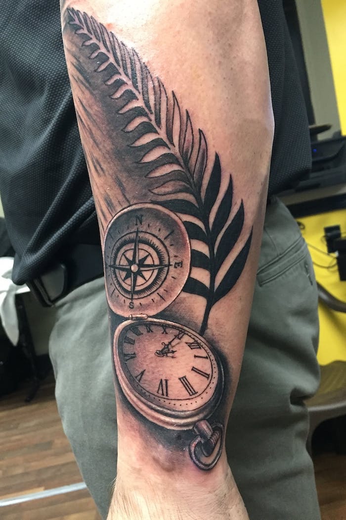 tattoos männer arm, taschenuhr in kombination mit kompass und großem feder