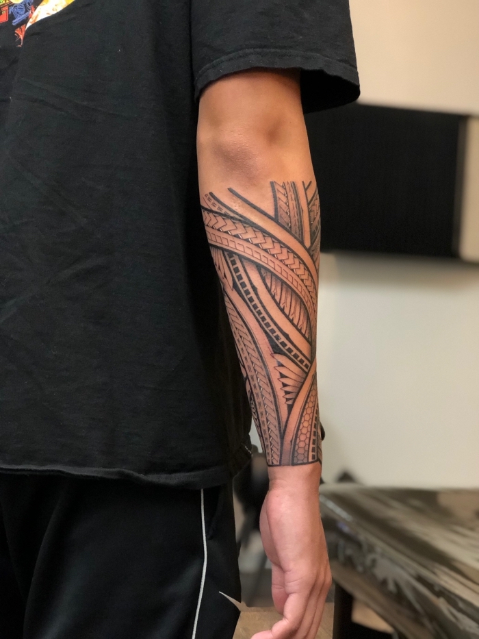 tribal tattoo designs für herren, schwarz graue tätowierung am unterarm, mann