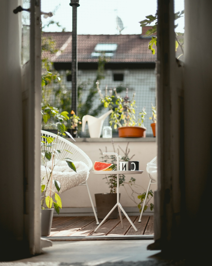 Möbel für kleinen Balkon, Dekoration mit Terrassenpflanzen, kleiner dreibeiniger Tisch, Stück Wassermelone