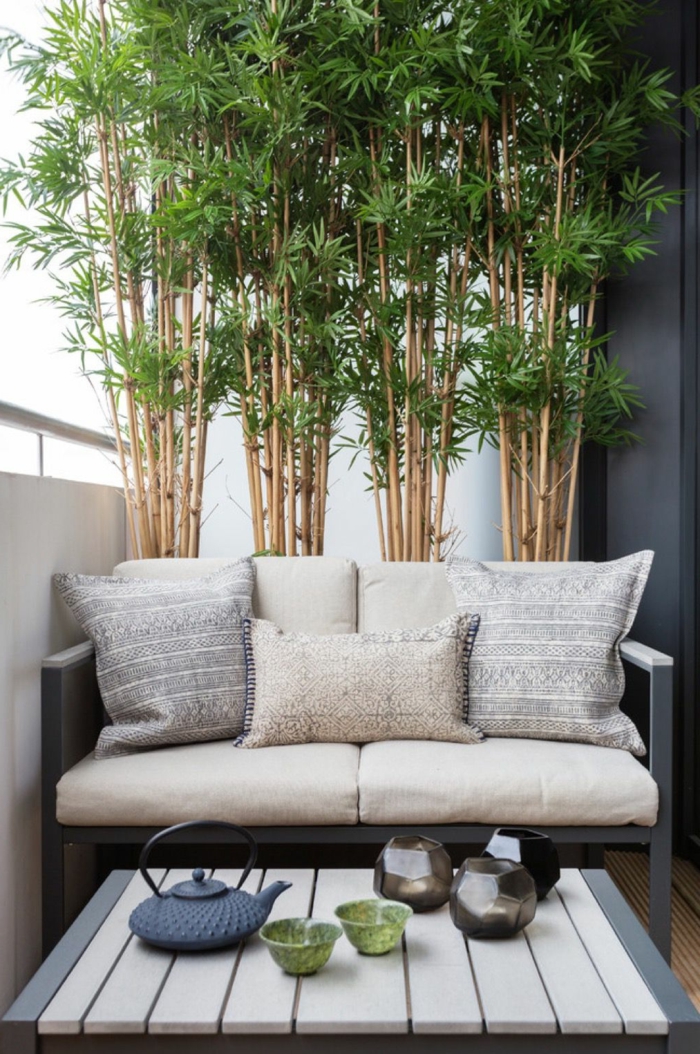 Ikea Outdoor. kleiner Balkon Ideen, großer dekorativer grüner Baum, beiges Sofa mit Kissen, 