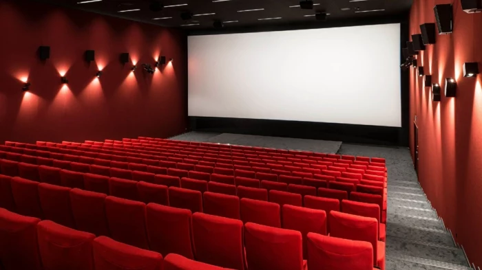 ein kino mit roten wänden und vielen roten sitzen, wegen covid 19 werden die kinos in deutschland geschlossen