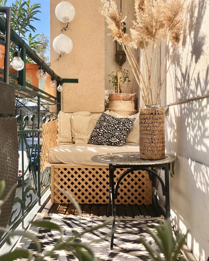 Eingerichtete Terrasse in hellen Farben, Balkonmöbel Set für kleinen Balkon, aufgehängte Lampen, schwarz weißer Teppich