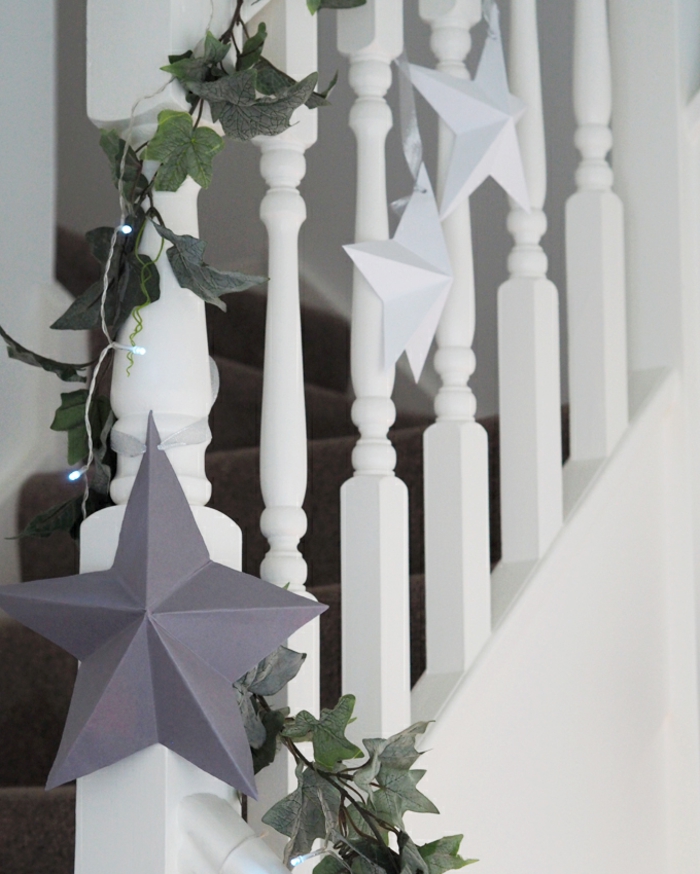 Origami Sterne falten Anleitung kostenlos, drei aufgehängte Sterne auf eine Treppe, in weiße und graue Farbe