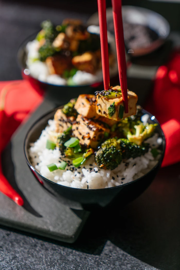 Seidetofu Würfel mit Brokkoli und Frühlingszwiebel auf Reis mit schwarzem Sesam