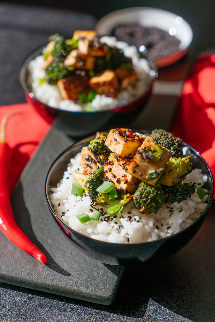 Seidentofu mit Brokkoli auf Reis servieren, mit schwarzem Sesam bestreuen 
