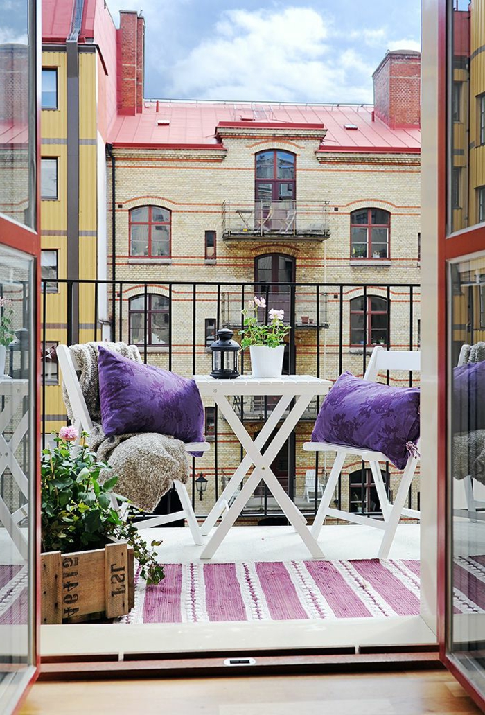 Terrasse Design in lila farbene Kissen und Teppich, Balkonmöbel Set für kleinen Balkon, alter Kiste mit Pflanze