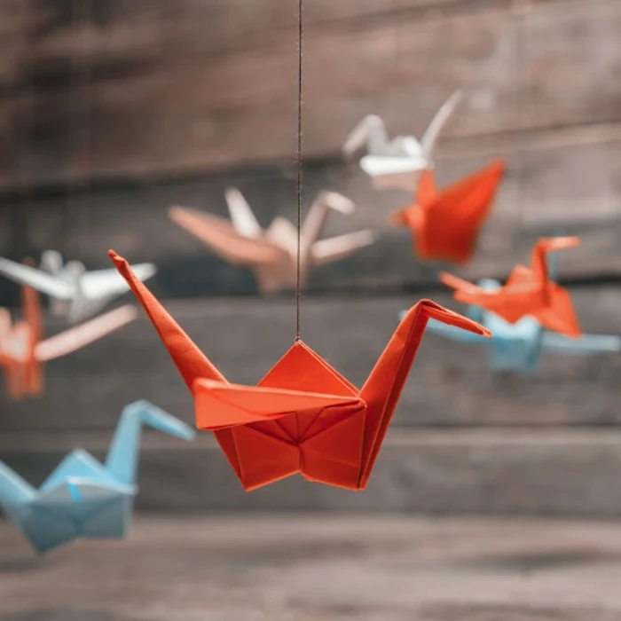 origineller Origami Kranich aus Papier in rot, Origami Tiere, japanische Faltkunst meistern