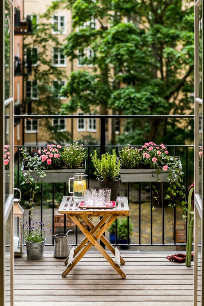 Balkon Lounge Klein, kleiner Esstisch aus Holz, Blumentöpfe mit pinken Blumen, Terrasse Inspiration