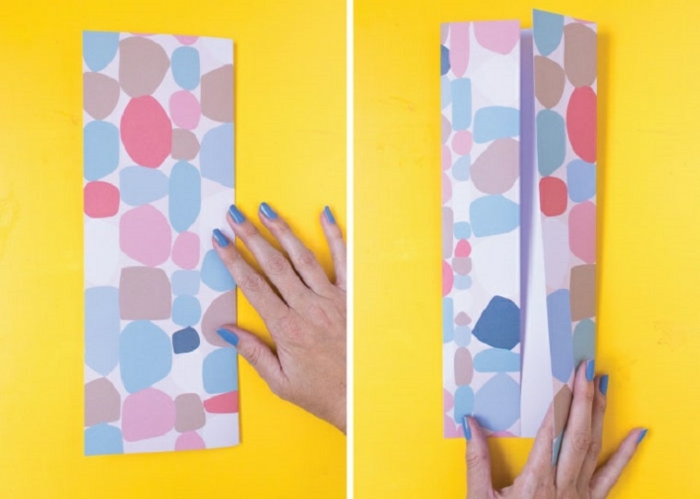Hand faltet ein großes buntes Blatt Papier, Anleitung zum basteln von Hemd Karte, origami anleitung einfach