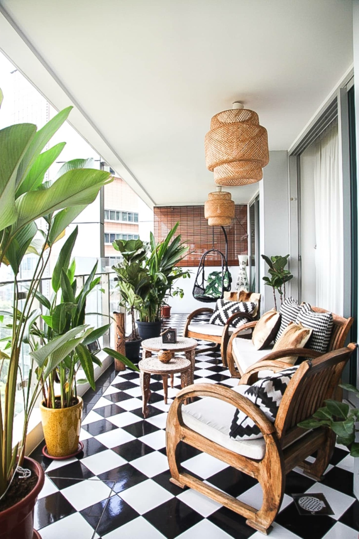 Einrichtung von Terrasse mit modernen Möbel aus Holz, schwarz weißer Boden, viele grüne Pflanzen