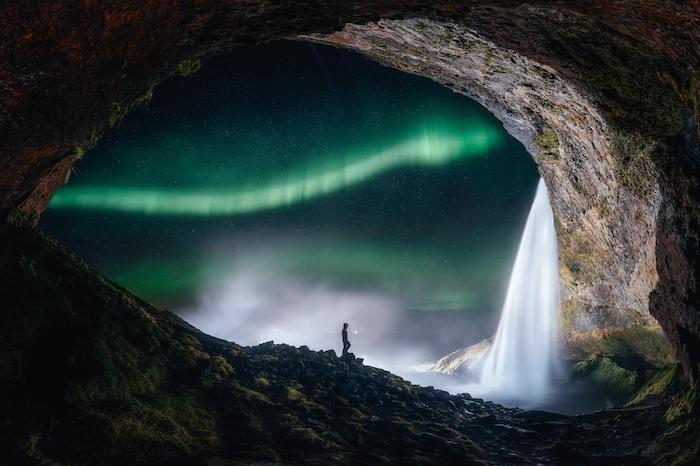 isaland, die sony world photography awards, eine höhle mit wasserfall und grüne polarlichter im himmel mit sternen
