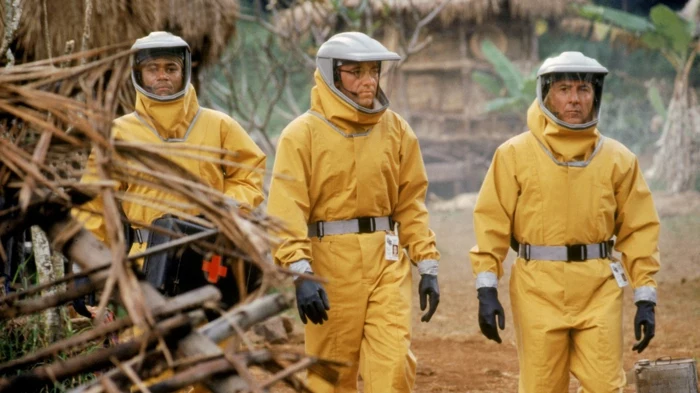 drei männer mit gelben schutzkostüms gegen viren, szene aus dem film outbreak mit dem schauspieler dustin hoffman, die besten filme über viren 