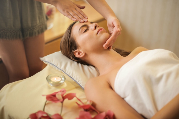 Massage und Hautpflege, kosmetische Dermatologie, Frau liegt auf einem Bett und lässt sich massieren, Laser Haarentfernung