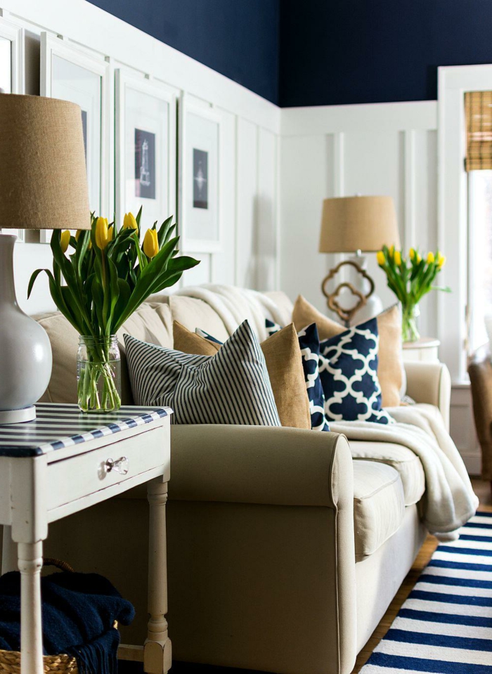 viele gelbe Tulpen, blau weißer Teppich, beiger Couch mit vielen bunten Kissen, Frühlingsdeko aus Naturmaterialien selber machen