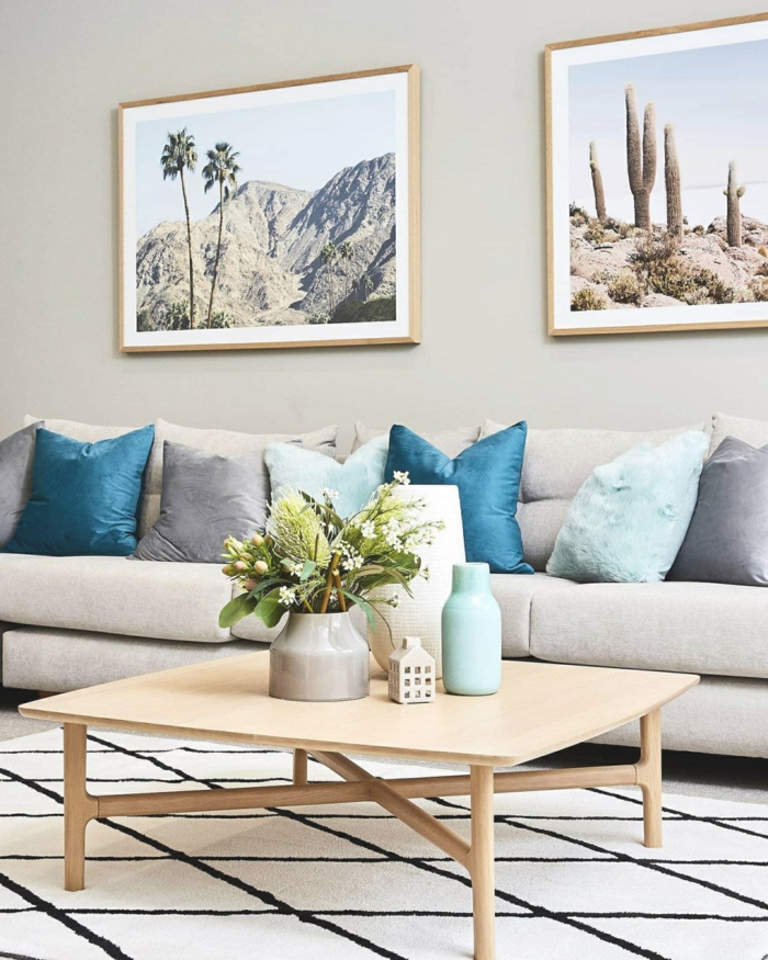 Deko für die Wohnung mit blauen Tönen, großes graues Sofa mit vielen Kissen, zwei Bilder an die Wand