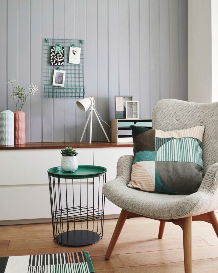 Pinterest Wohnzimmer modern einrichten, bunter Kissen auf einem grauen Stuhl, grüner Korbtisch, grau bemalte Wand