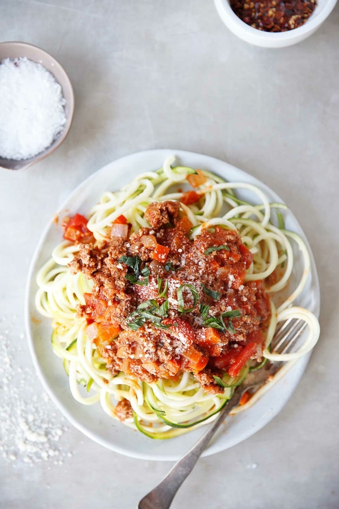 zucchini spaghetti bolognese garniert mit parmesan, paasta mit hachfleisch und tomatensoße