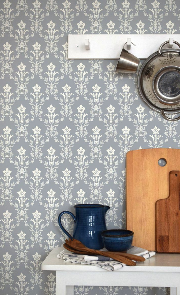 Interior Design im skandinavischen Stil, blaue Tapete Küche Landhaus, mit Blumenmotiven, blauer Keramikbecher und Keramikkanne, Schneidebrett aus Holz