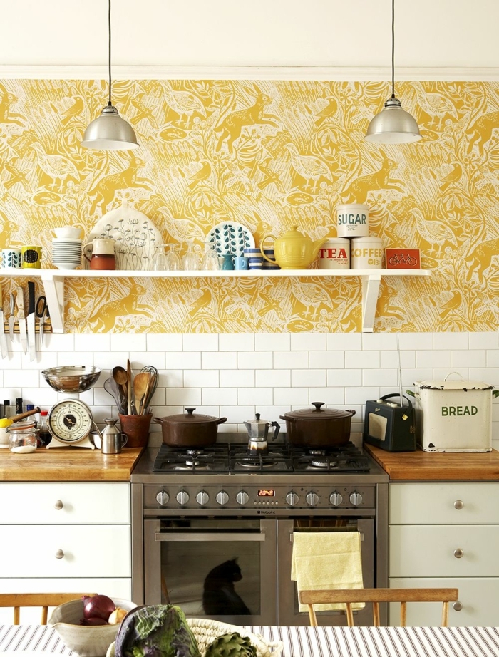 Ausstattung vom Haus im Landhaus Stil, weiße Fliesen, gelbe Küchentapeten mit verschiedenen Tieren 