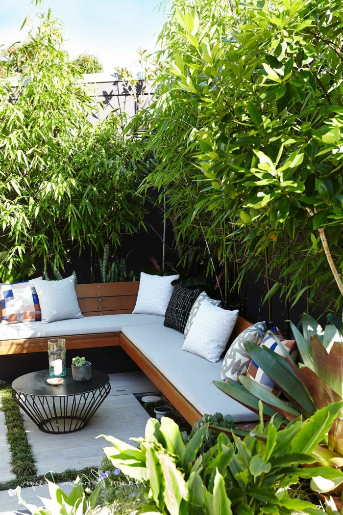 Sichtschutz Garten Ideen Selber machen mit großen Pflanzen, Ecksofa mit weißer Polsterung und schwarzen Kissen