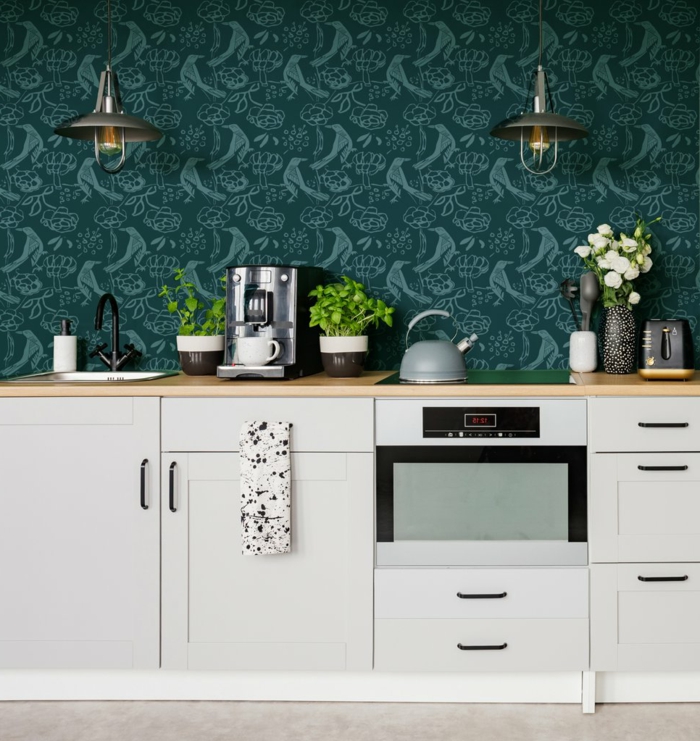 grüne Wand mit Lampen, elegante Küche mit weißen Möbeln, Pflanzen und Kaffeemaschine, Küchentapeten Inspiration