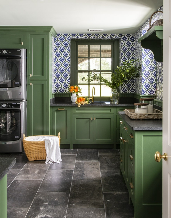 elegante Möbel in grüner Farbe, schwarze Waschmaschine und Trockner, Küchenwände gestalten mit blauen Tapeten