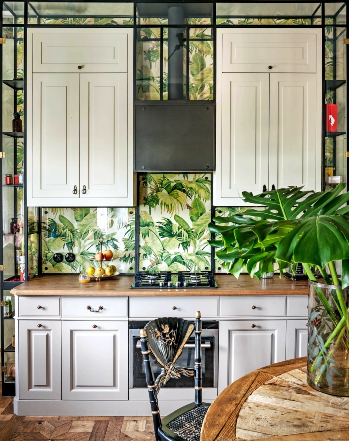 große weiße Schränke, grüne Blätter in Vase, Wandgestaltung Küche Beispiele, Tapten mit tropischen Mustern
