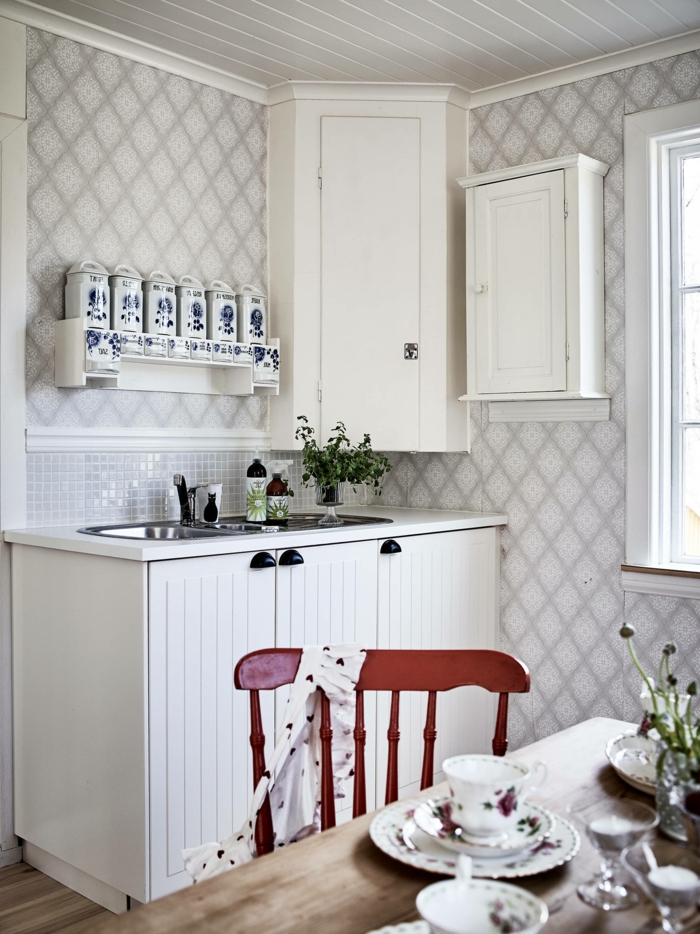 Tapete Küche Landhaus, kleine Küche mit Fenster, weiße Schränke, roter Stuhl aus Holz
