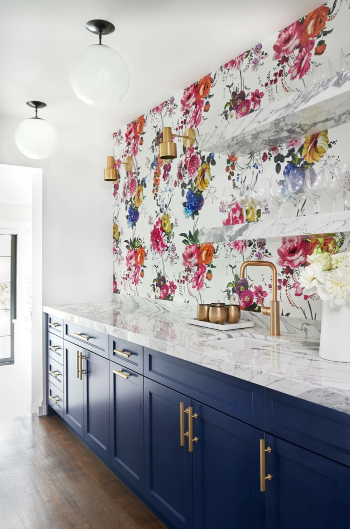 modern gestaltete Küche mit blauen Schränke und Theke aus Marmor, Küchentapeten ganz aktuell mit floralem Muster