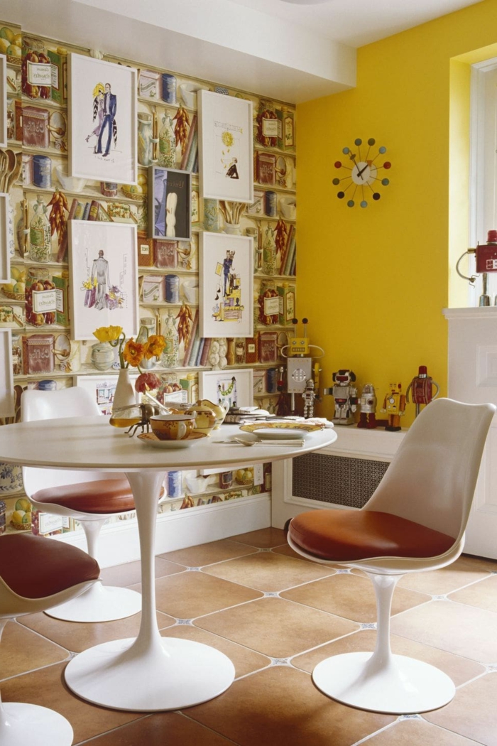 helle gelbe Wand, Tapete Esszimmer mit abgebildeten Büchern, runder Tisch mit retro Stühlen