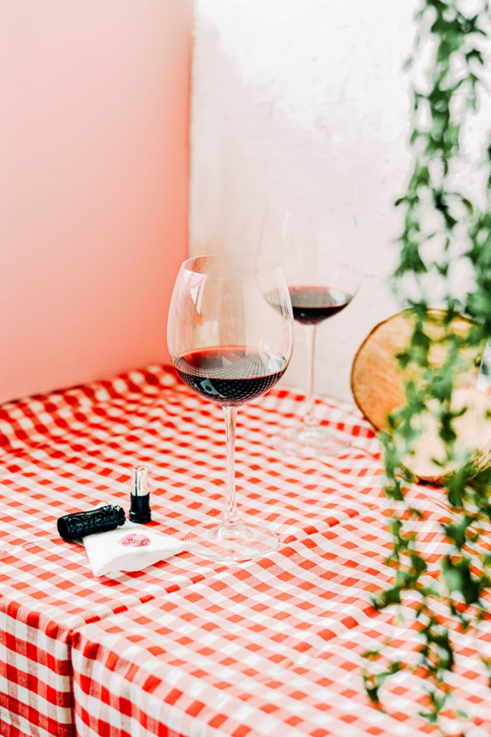 Tisch mit zwei großen Kristall Weingläser, Tischdecke mit weißen und roten Vierecke, Kristallgläser für Wein