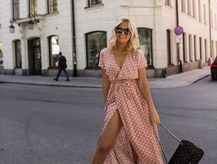 inspor street style lange sommerkleider pink mit polka dots kleine schwarze tasche weiße sneakers kurze blonde haare