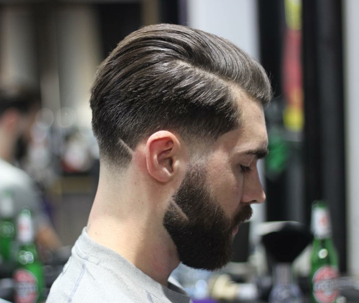 Foto von einem jungen Mann mit modischem Haarschnitt, Männer Frisuren kurz 2020, braune Haare und buschiger Bart 