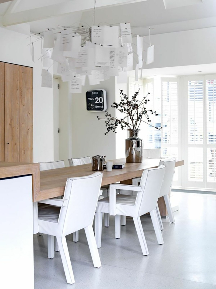 Kücheninsel mit Sitzgelegenheit, Holztisch mit weißen Stühlen, interessante Dekoration, große Vase aus Metall mit Blumen