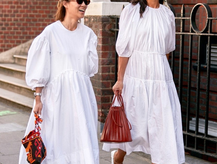 street style inspiration zwei elegante frauen sommerkleid weiß lang weiße und schwarze schuhe rote taschen