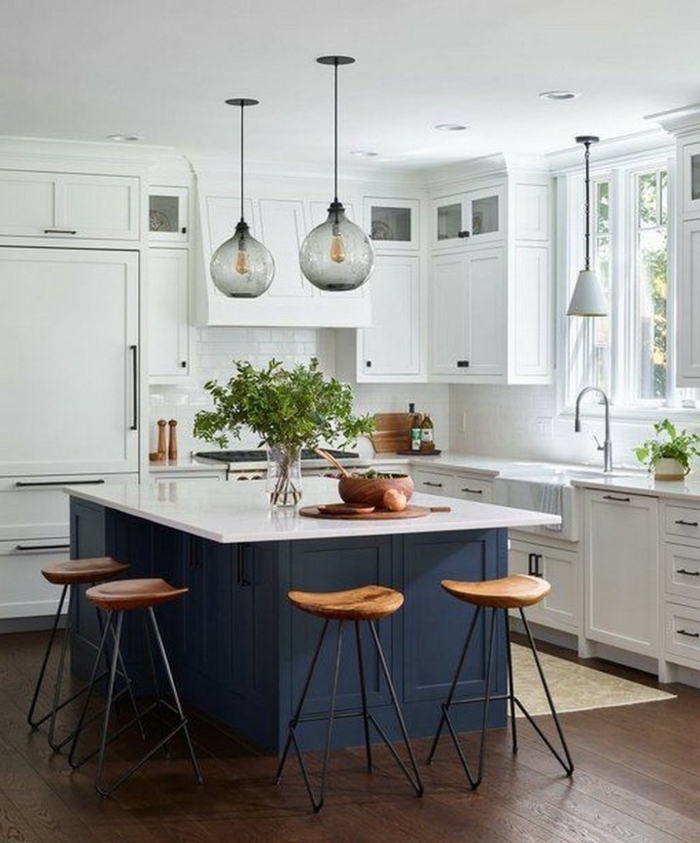 Kücheninsel mit Sitzgelegenheit, weiße Küche mit blauer Theke und kleinem Fenster, Holzboden mit Teppich, modische Beluchtung