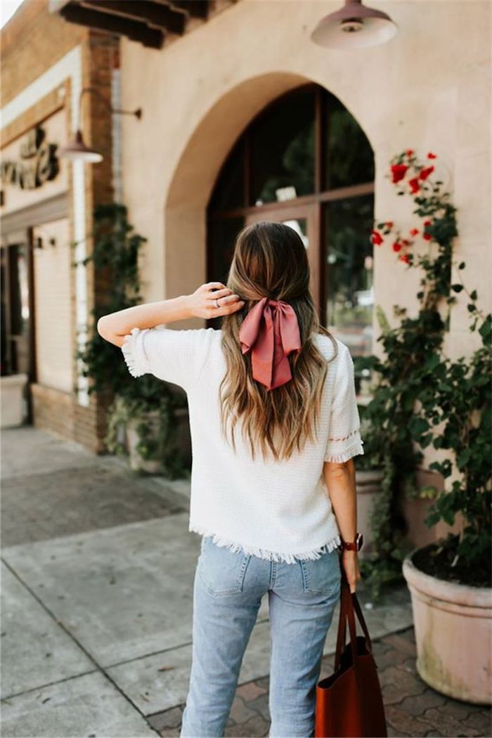 casual street style jeans weiße bluse rote maxi tasche mittellange haare mit pinker schleife braune haare mit strähnen blond