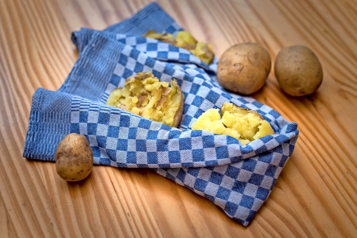 ein blaues handtuch mit zerdrückten kartoffeln hausmittel gegen husten ein tisch aus holz