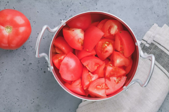 ein topf mit vielen roten gehakten tomaten wie kann man tomaten einkochen rezepte eine schritt für schritt anleitung
