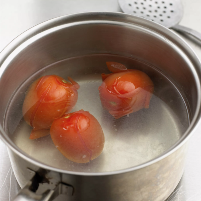 ein topf mit wasser und mit drei roten großen tomaten tomaten einkochen rezepte