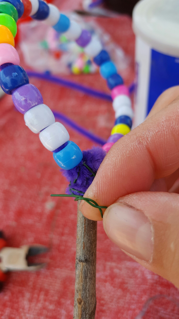 eine hand eines kindes basteln mit kindern seifenblsen selber machen diy anleitung stabile seifenblasen rezept ein stab für seifenblasen mit künstlihen perlen