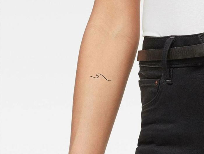 schlichte welle tattoo minimalistische tattoos auf dem arm weißes t shirt schwarze jeans
