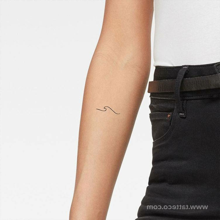 schlichte welle tattoo minimalistische tattoos auf dem arm weißes t shirt schwarze jeans 