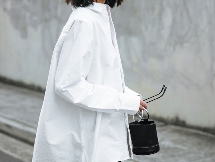 stylisches outfit oversized hemd in weiß weite schwarze hosen mini tasche kurze braune haare kurzhaarfrisuren 2020