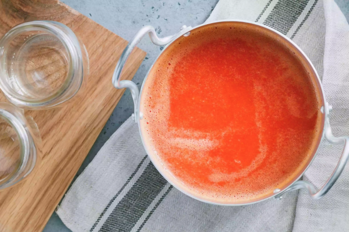 wie kann man tomaten einkochen rezepte ein topf mit einer roten sauce aus tomaten ein schneidebrett