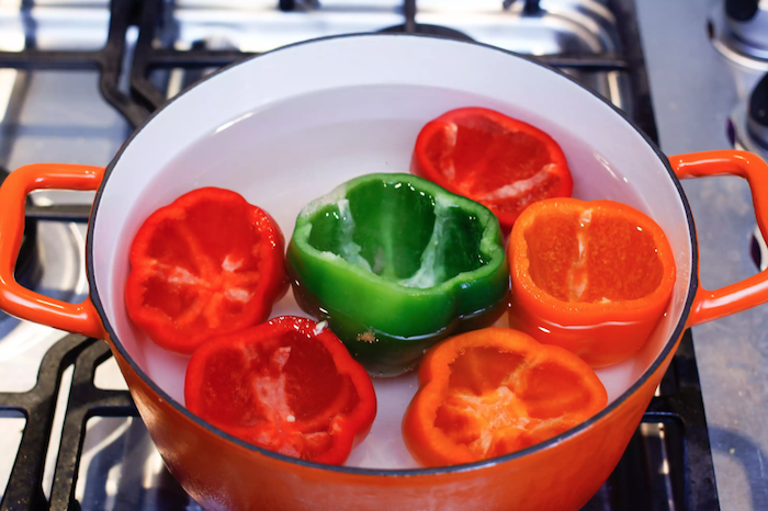 wie kocht man gefüllte paprika hackfleisch ein topf mit wasser und roten und grünen paprikaschoten