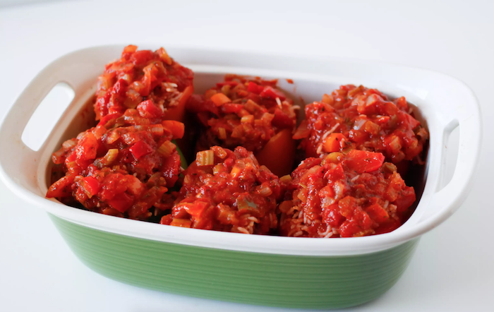 wie kocht man gefüllte paprika tomatensoße schüssel mit roter tomatensoße und gefüllten paprikaschoten