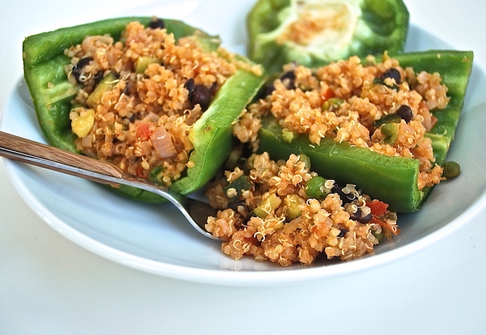 wie kocht man gefüllte paprika vegetarisch ein teller mit gefüllten grünen paprikaschoten mit couscous