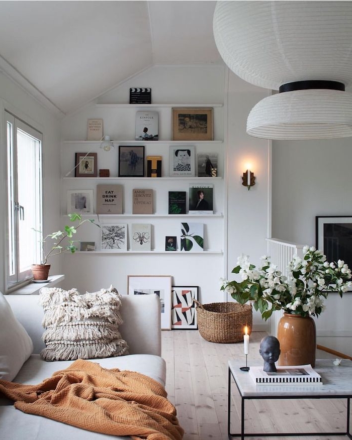 dekoration kleines wohnzimmer scandi style viele deco bilder vase mit weißen blumen kaffeetisch mit schwarzen beinen