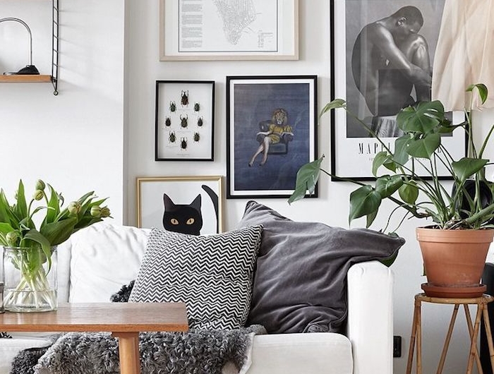 dekoration wohnung mit pflanzen weißer couch graue kissen kaffeetisch aus holz aufgehängte bilder und zeichnungen möbel skandinavisch